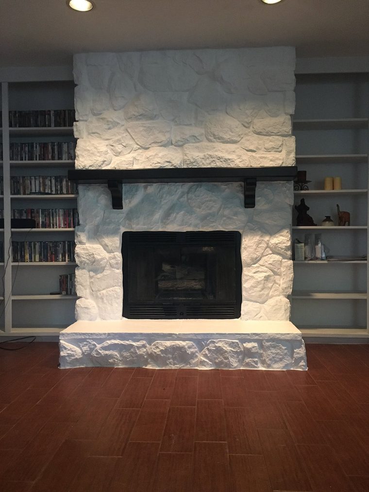 The same stone fireplace after painting, finished in white